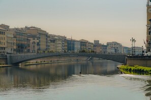 Une rivière avec un pont, des bâtiments le long de la rive et un bateau.