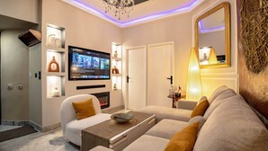 Un salon moderne avec un téléviseur à écran plat, un canapé et des objets de décoration.