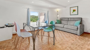 Una habitación con una mesa de comedor, sillas, un sofá y una ventana con vistas.