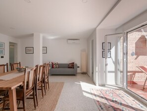 Ein modernes Interieur mit Essbereich, einer Couch und einer Glastür, die nach draußen führt.