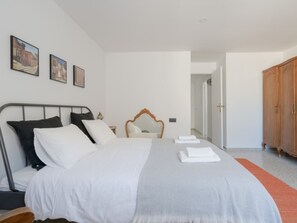 Ein Schlafzimmer mit einem Bett, einem Holzschrank und einer Tür zu einem anderen Raum.