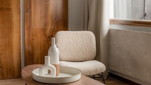 A room with a wooden wardrobe, a white chair, and a table with a white ceramic tray holding two white vases. - Renovated duplex near station - 6 guests (Arâches-la-Frasse)