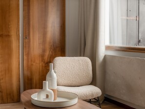 A room with a wooden wardrobe, a white chair, and a table with a white ceramic tray holding two white vases. - Renovated duplex near station - 6 guests (Arâches-la-Frasse)