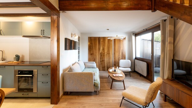 A modern interior with a kitchen, seating area, and a large window. - Renovated duplex near station - 6 guests (Arâches-la-Frasse)