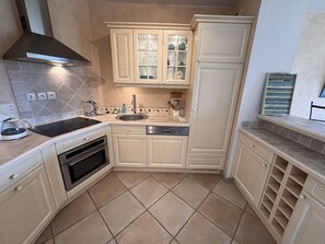 A kitchen with a stove, oven, sink, and cabinets. - Central village apartment, open view (La Croix-Valmer)