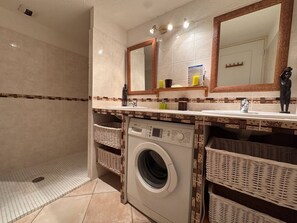 A bathroom with a washing machine, two sinks, a mirror, and wicker baskets. - Central village apartment, open view (La Croix-Valmer)