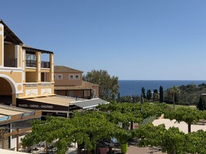 Ein Küstenhotel mit Meerblick, Sitzgelegenheiten im Freien und einem Restaurant namens 'Glaces - Crêpes - Gaufres'.