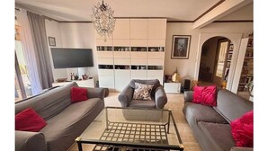Ein modernes Wohnzimmer mit einer Couch, einem Sessel und einem Glastisch.