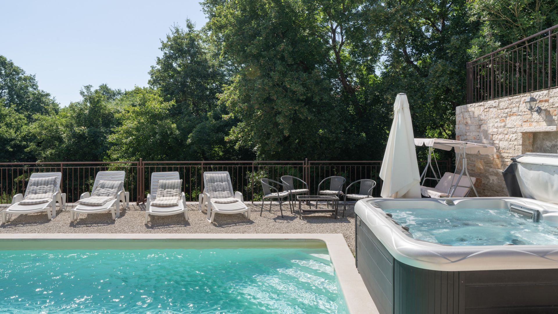 Un área de piscina con sillones de descanso y un jacuzzi.
