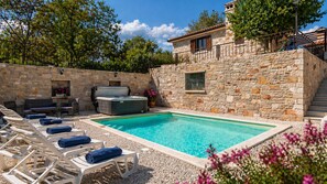 A stone-walled pool area with lounge chairs and a hot tub. - Villa Zebo by Villas Guide (Barban)
