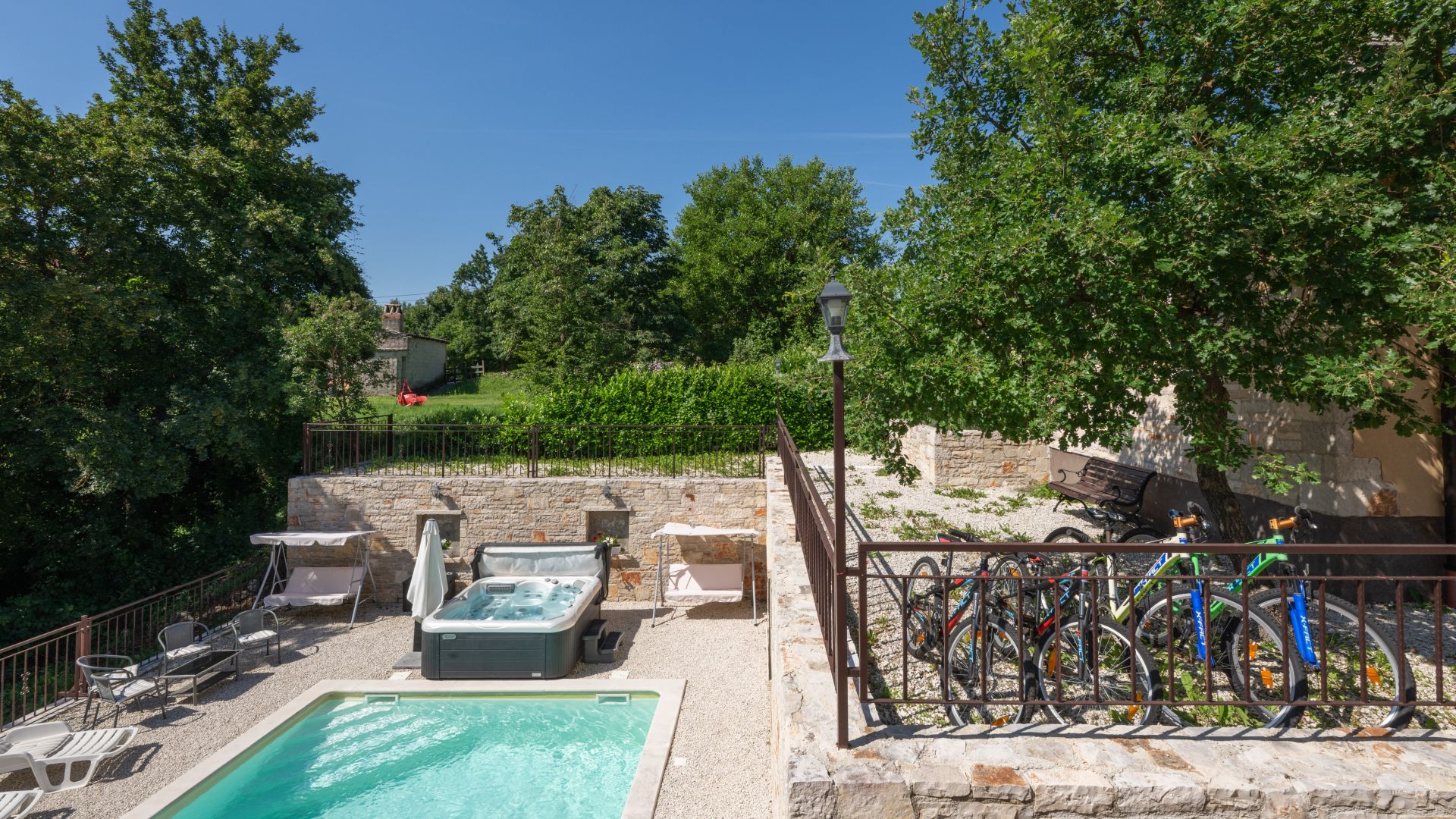A pool area with hot tubs, a seating area, and bicycles.
