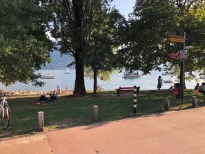 A lakeside park with a bench, a bicycle, and a signpost with directions. - Apartment in the park (Minusio)