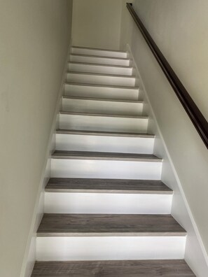 Eine Treppe mit abwechselnd weißen und dunklen Holzhäuschen, die nach oben führt.