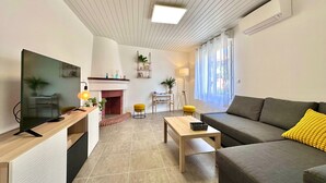 Una sala de estar moderna con chimenea, un sofá, una mesa de centro y un televisor.