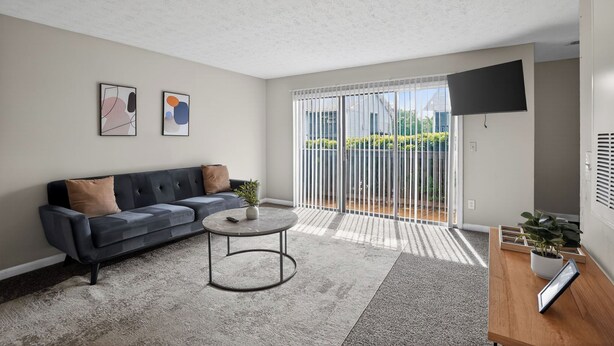 Ein modernes Wohnzimmer mit einer Couch, einem Couchtisch und Kunstwerken an der Wand.