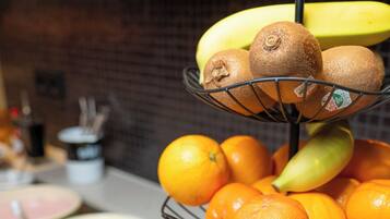 A fruit display with bananas, kiwis, oranges, pears, and apples.