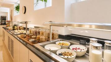 Een buffet met diverse soorten eten en een melkdispenser.