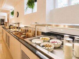Een buffet met diverse soorten eten en een melkdispenser.