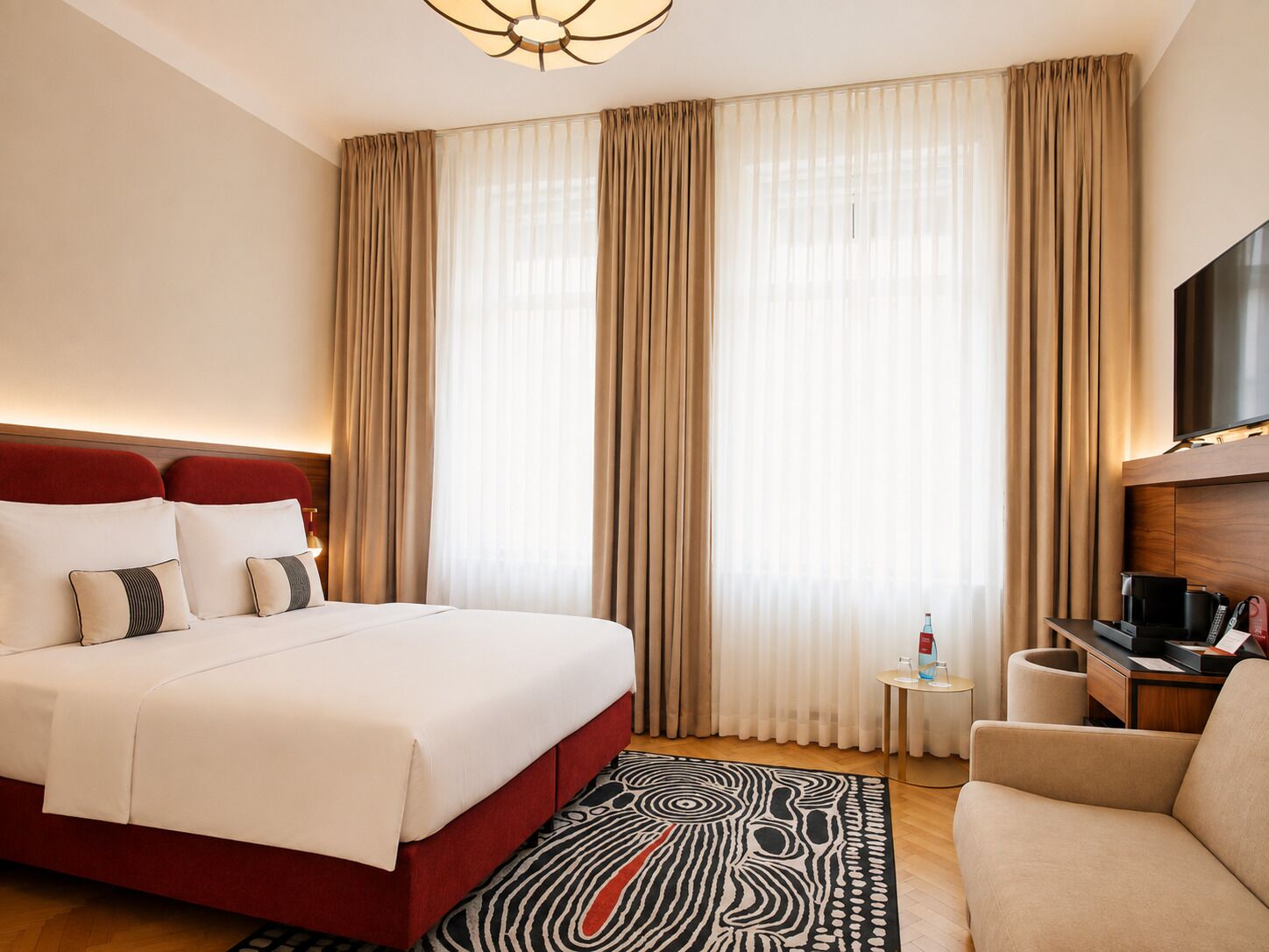 Une chambre d’hôtel avec un lit, une télévision, un bureau et une chaise.