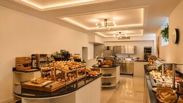 Uma cozinha moderna com uma ilha central, equipada com diversos eletrodomésticos e um serviço de buffet.