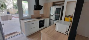 A modern kitchen with a built-in oven, a microwave, and a sink. - Upper Cassis with ocean views, 92m² air-conditioned apartment, swimming pool in the complex (Cassis)