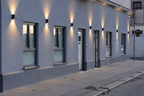 Ein modernes Gebäude mit Außenbeleuchtung, großen Fenstern und einer sauberen Fassade.