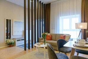 Ein modernes Wohnzimmer mit Sofa, Couchtisch und Essbereich.