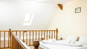 A bedroom with a wooden bed, a small bedside table, a window, and a staircase. - Apartment Sleeps 4 With Pets Welcome (Timisoara)