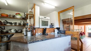Eine Küche mit Granit Arbeitsplatten, Edelstahlgeräten und Holzregalen.
