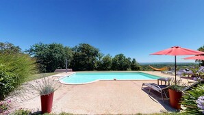 A swimming pool with a view of trees and a distant landscape. - PASTOUREAU (Sainte-Foy-de-Longas)