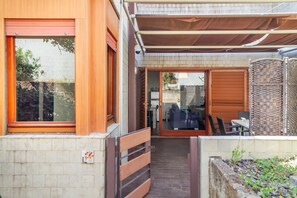 Ein modernes Haus mit überdachter Terrasse, einer Schiebetür und einer Ziegelaußenwand.