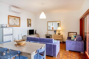 Ein gemütlicher Wohnbereich mit Essplatz, Sofa und Fernseher.