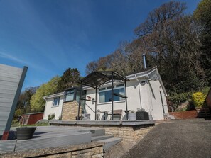 A modern house with a covered patio, stone facade, and a satellite dish. - Crown Cottage (Dunfermline)