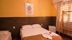 A hotel room with a bed, a bedside table, an air conditioning unit, a towel rack, and a framed picture on the wall. - Pousada SolMaris (João Pessoa)