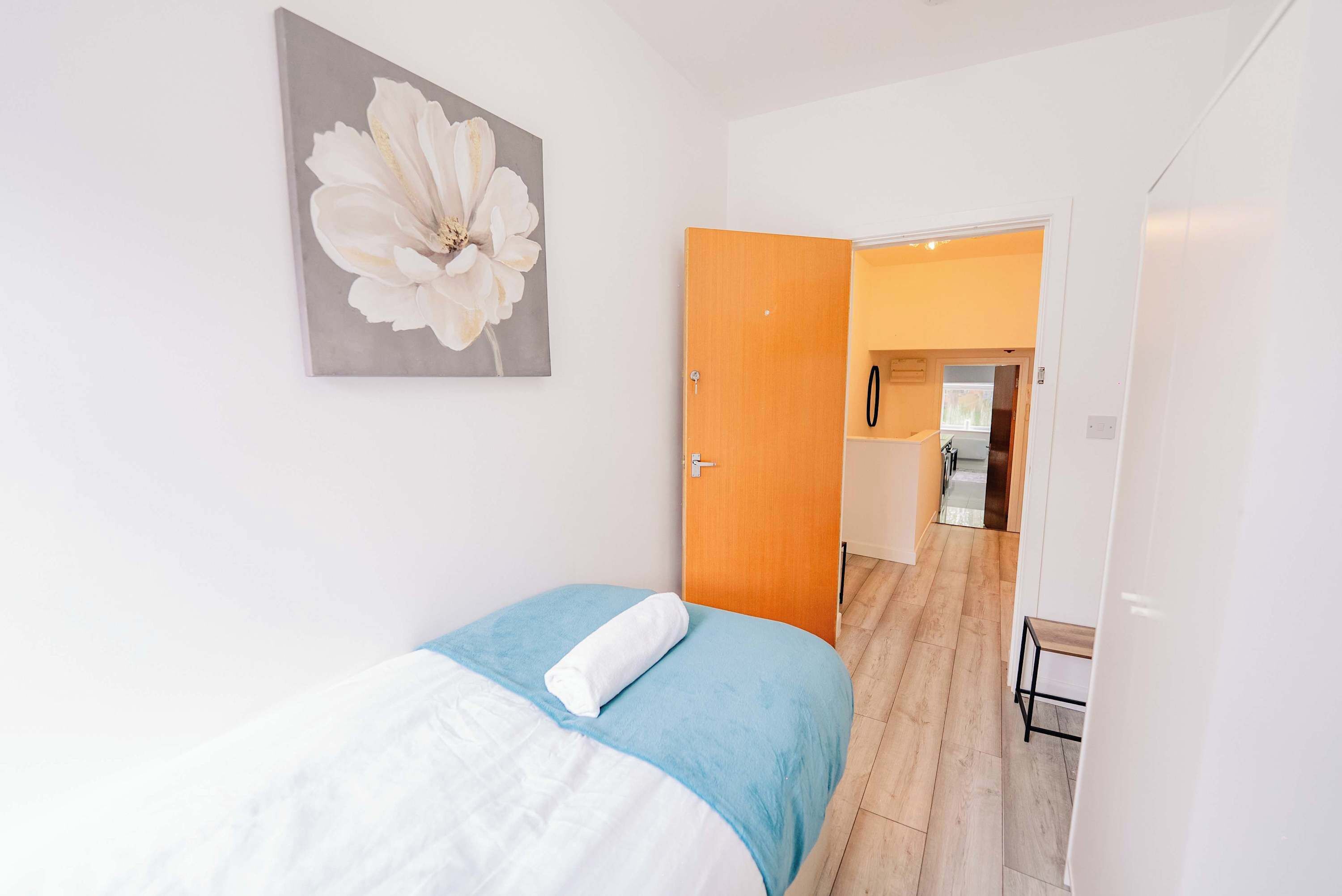 Une chambre avec un lit, une porte donnant sur une salle de bain et un couloir.