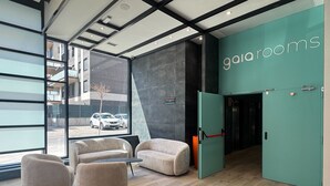 A modern interior with a teal accent wall, a reception desk, and seating area.