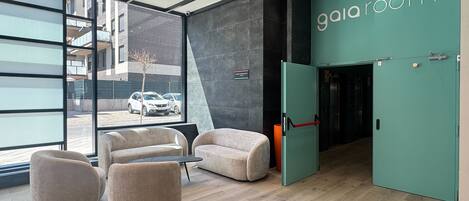 A modern interior with a teal accent wall, a reception desk, and seating area.