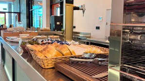 A buffet setup with bread, condiments, and a coffee machine.