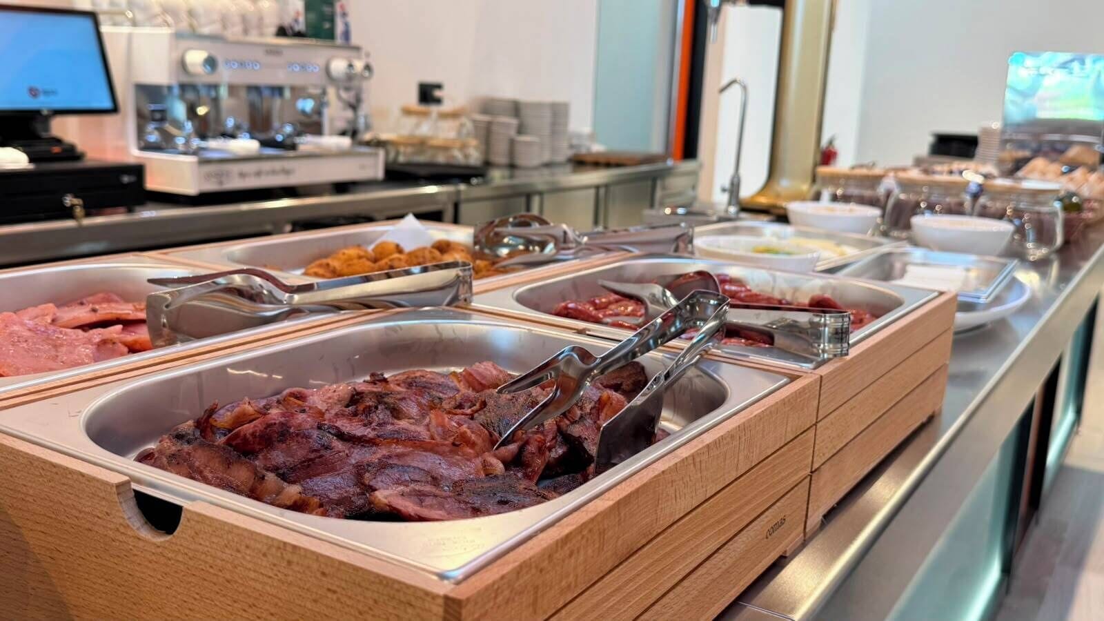 A buffet with various food items and utensils.