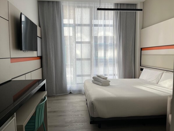 Literie de qualité, couette en duvet, bureau, rideaux d’obscurcissement
