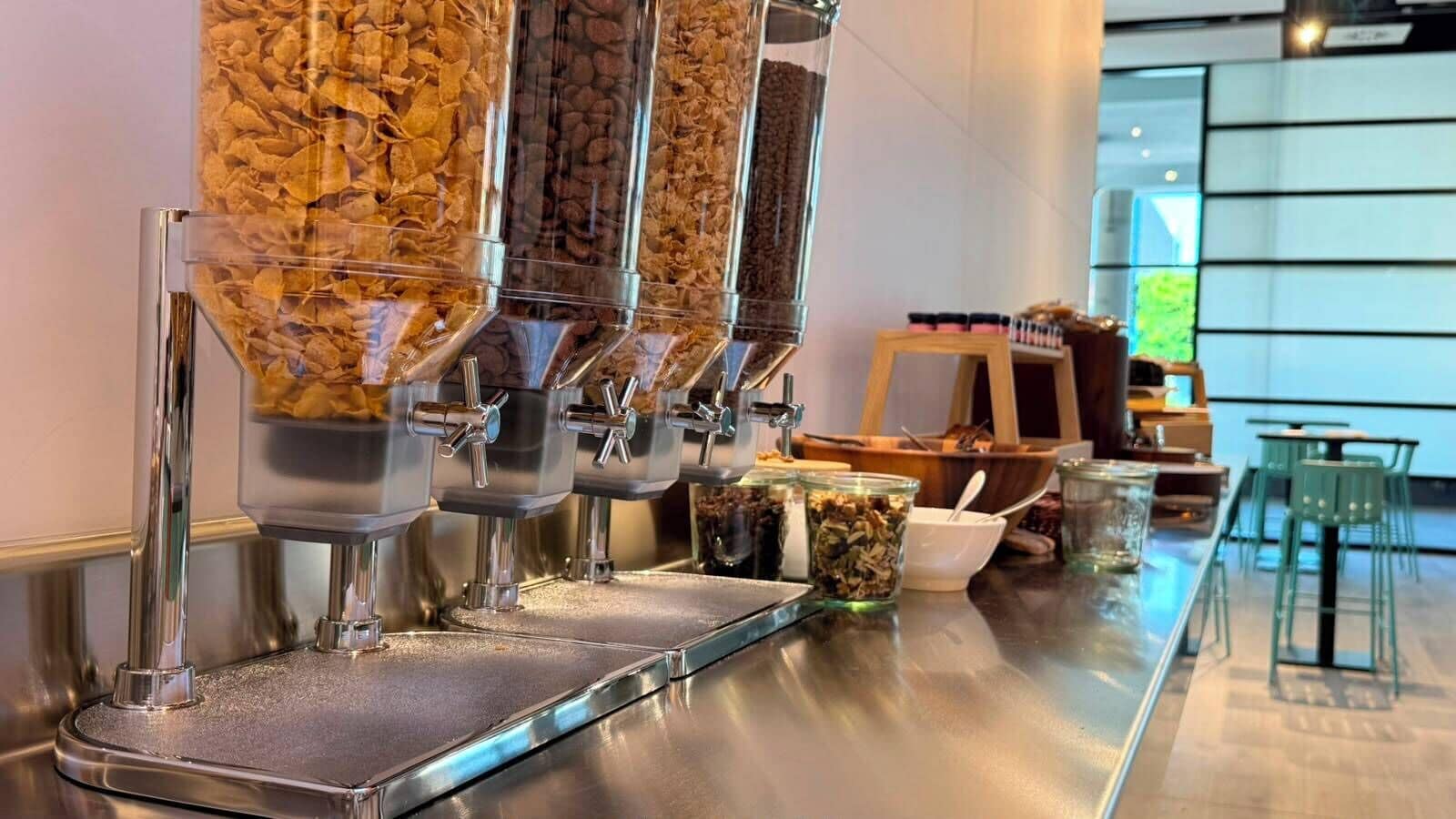 A coffee bar with multiple dispensers, a wooden counter, and a view of the interior.