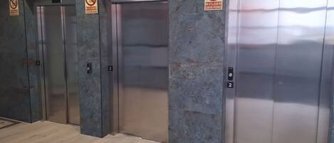 Cuatro puertas de ascensor con un cartel de 'No Smoking' encima de cada una, y el número '2' en las puertas.