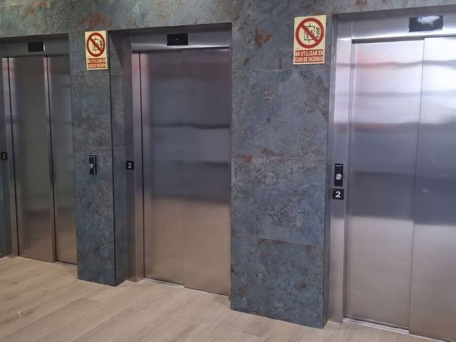 Cuatro puertas de ascensor con un cartel de 'No Smoking' encima de cada una, y el número '2' en las puertas.