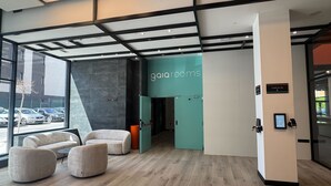 A modern interior with a check-in desk, seating area, and a view of parked cars outside.