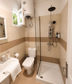 Economy bungalow | Badkamer | Een douche, gratis toiletartikelen, een haardroger, pantoffels