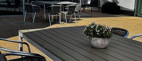 An outdoor seating area with a table, chairs, and a potted plant.