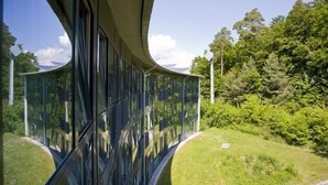 Un edificio moderno con fachada de vidrio curvada que refleja el entorno.