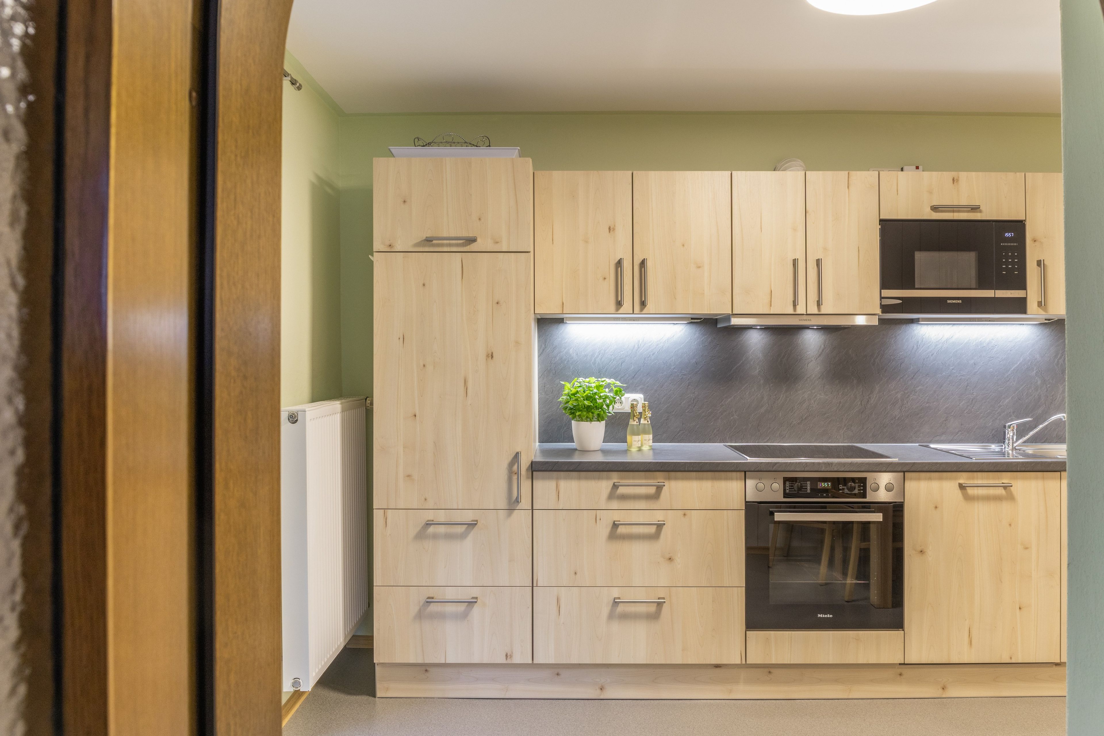 A modern kitchen with wooden cabinets, a built-in microwave, a dishwasher, and a sink.