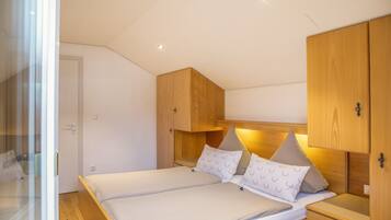 A bedroom with a bed, bedside tables, and wooden cabinets.