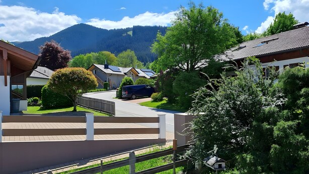 Ein Wohngebiet mit Häusern, einer Straße und einem Berg im Hintergrund.